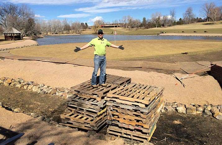 Bruce checks the base of the pallet bridge that was built to access 17 green at Cherry Hills Country Club, CO., in preparation for sodding the green.