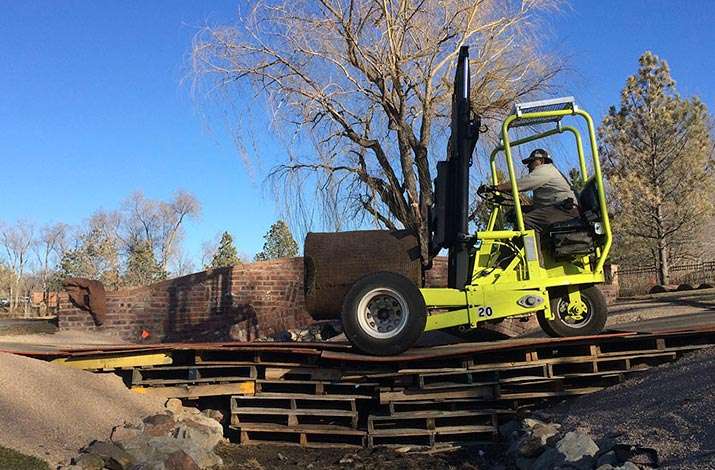A big roll of GVT Short Cut Bluegrass sod is transported across a construction bridge on a Donkey forklift to 17 island green at Cherry Hills Country Club in Cherry Hills Village, CO.