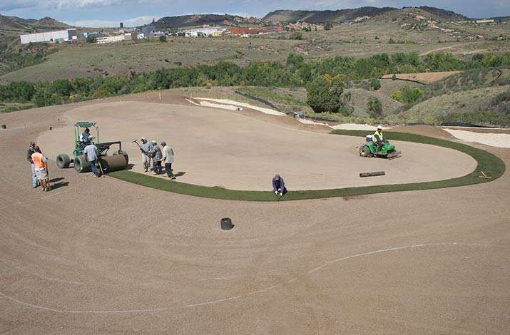 A green is ringed with big rolls of GVT Short Cut Blue sod in Littleton, CO at The Club at Ravenna.