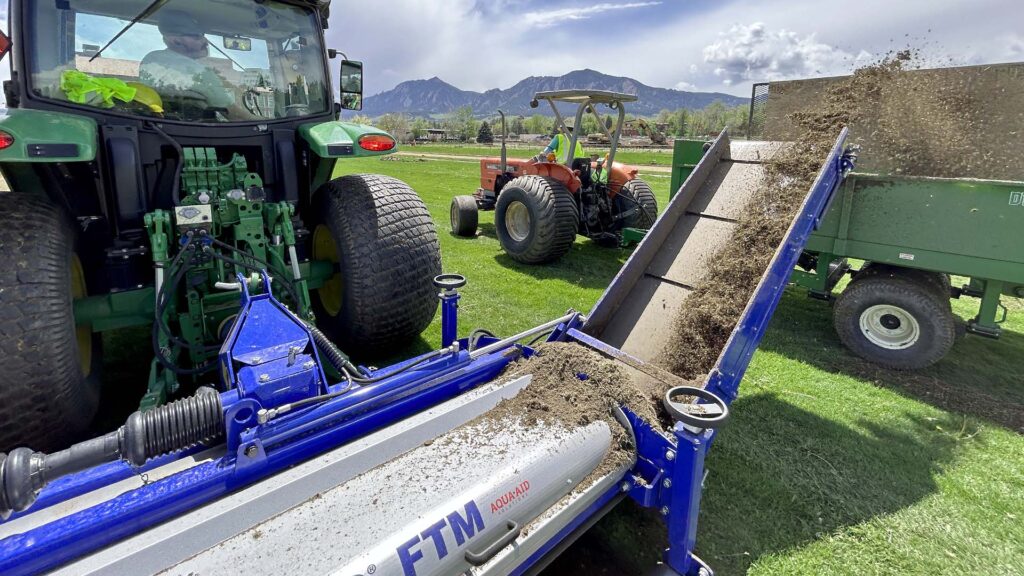 A Koro Topmaker removes sod from a sports field on the University of Colorado east campus.